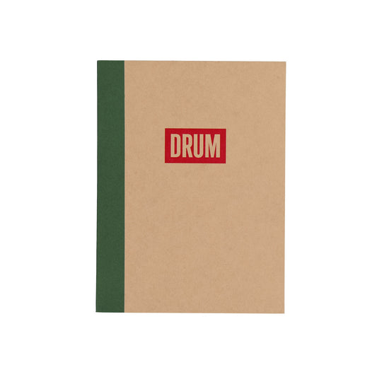 Notebook with a red 'DRUM' logo on a beige cover and green spine.