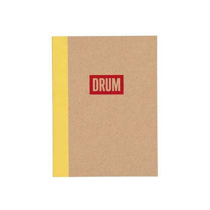 Notebook with a red 'DRUM' logo on a beige cover and yellow spine.