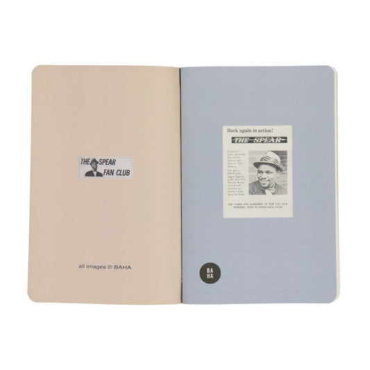 Open notebook with beige and gray pages featuring 'The Spear Fan Club' and a newspaper clipping.