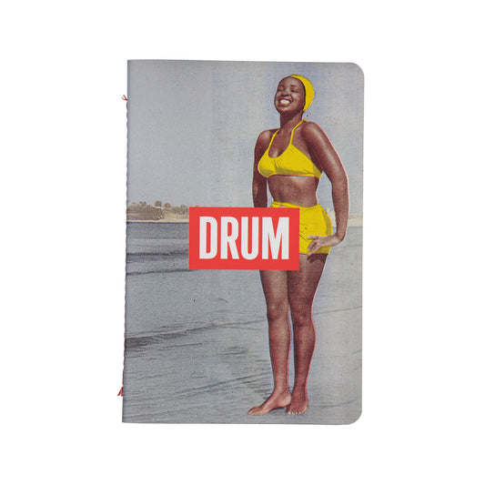 Notebook with a woman in a yellow swimsuit on the cover, featuring the brand 'DRUM'.
