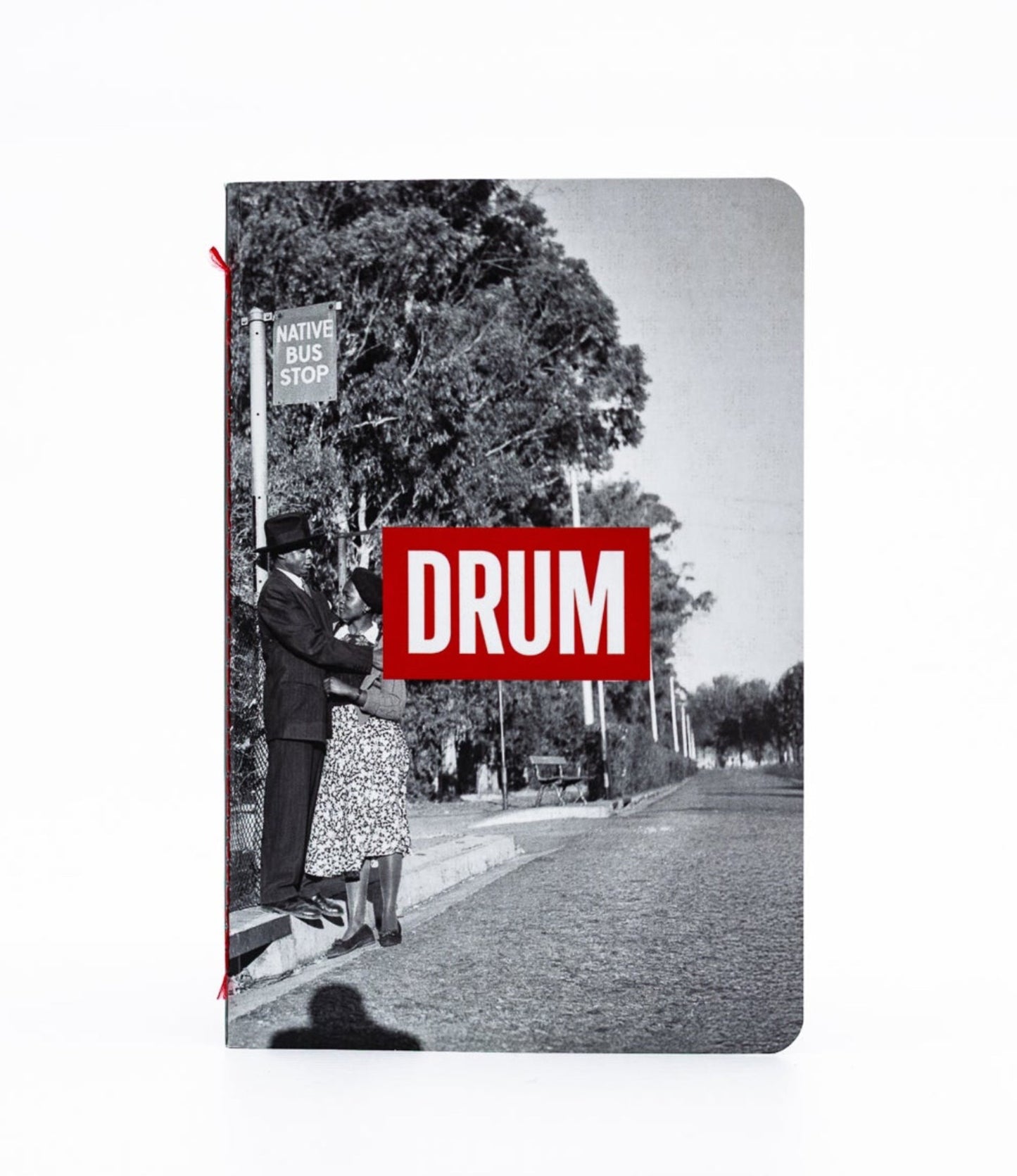Notebook with a black and white photo of a street scene and a red 'DRUM' logo on the cover.
