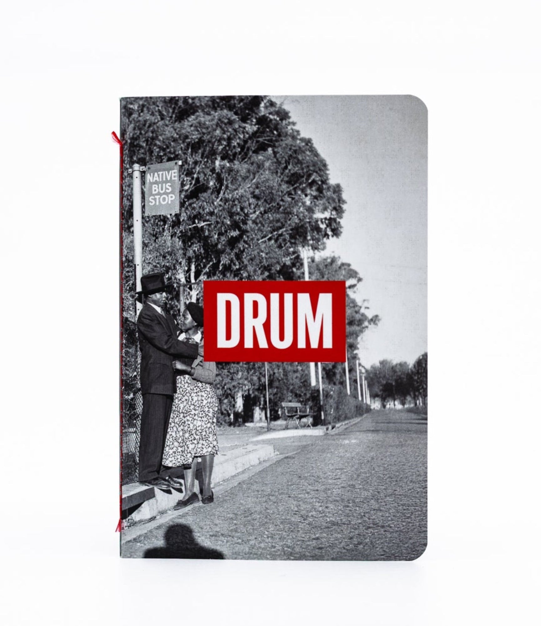 Notebook with a black and white photo of a street scene and a red 'DRUM' logo on the cover.