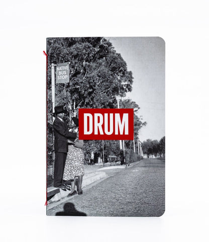 Notebook with a black and white photo of a street scene and a red 'DRUM' logo on the cover.