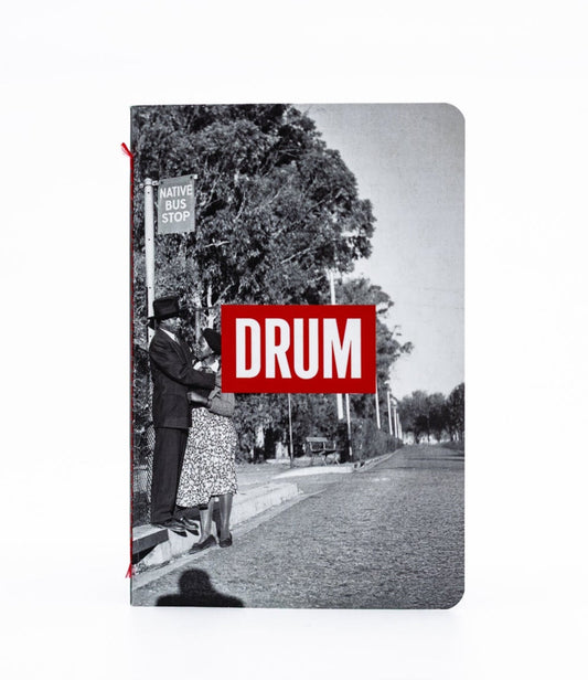 Notebook with a black and white photo of a street scene and a red 'DRUM' logo on the cover.
