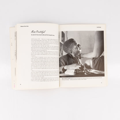 Open book with a black and white photo of a person sitting at a desk on the right page.