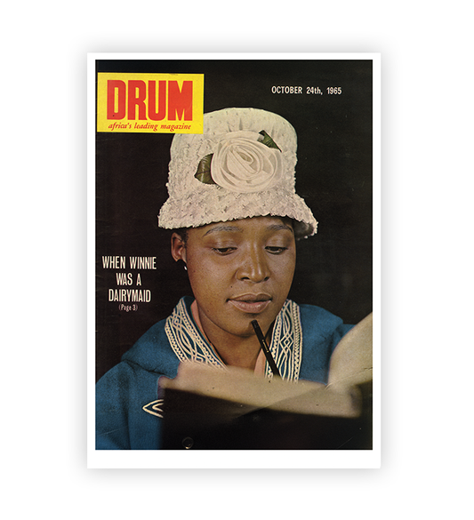 Magazine cover featuring a woman wearing a white hat with a flower, holding a book, and the title 'DRUM'.